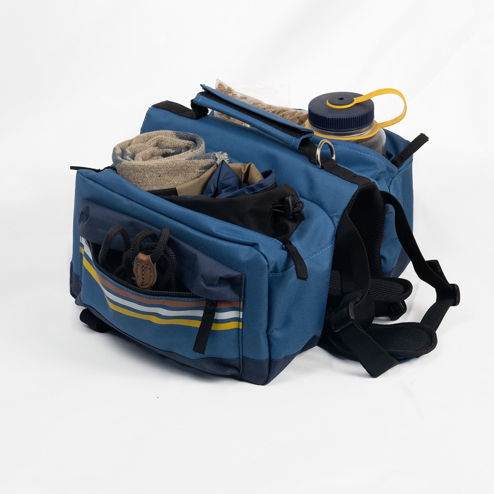 Spacious dog backpack packed with hiking essentials, highlighting its large storage capacity for outdoor gear.